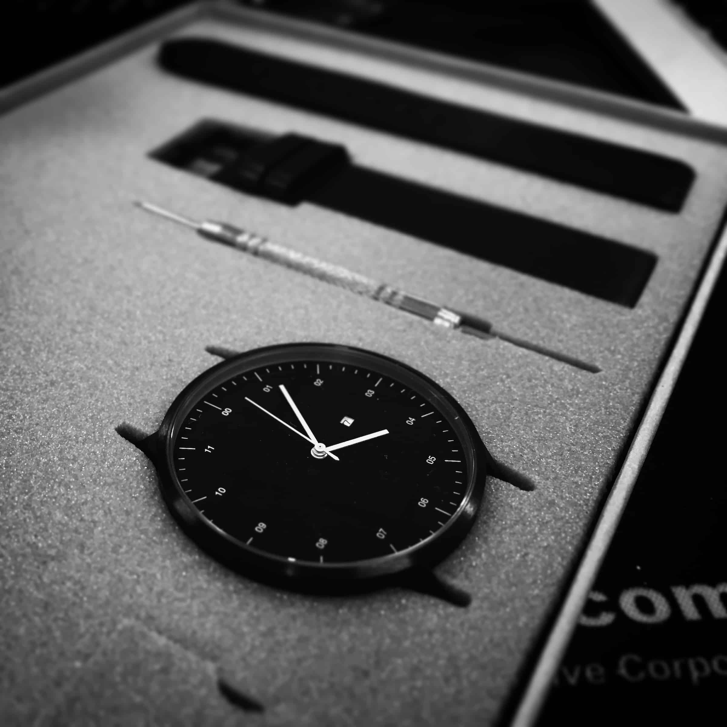 Black analog watch in a black box
